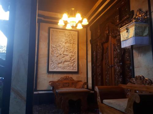 a room with a painting on the wall and a chandelier at Indy House in Ubud