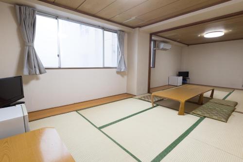 a living room with a table and a large window at Suimeiso in Oshu