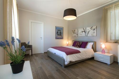 a bedroom with a bed and a table and a lamp at Apartments La Lombarda Centro Storico Stresa in Stresa