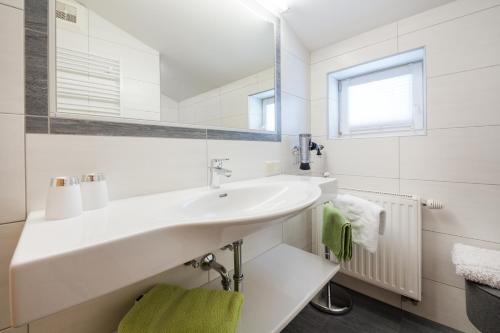 a white bathroom with a sink and a mirror at Martina und Herbert Scherer in Wagrain