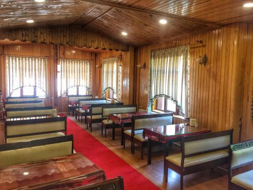 a dining room with tables and chairs and wooden walls at Uğur Motel in Uzungöl