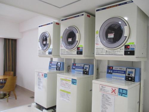 a laundry room with three washing machines on display at Chisun Grand Nagano in Nagano