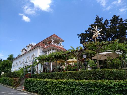 Un edificio blanco con sombrillas delante. en Hotel Domittner, en Klöch