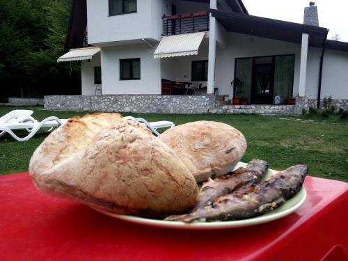 a plate of food on a table with bread and sausage at Casuta Didi in Brezoi