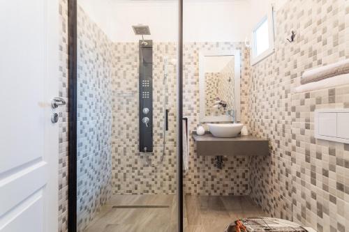 ein Bad mit einem Waschbecken und einer Glastür in der Unterkunft Bright House in Bukarest