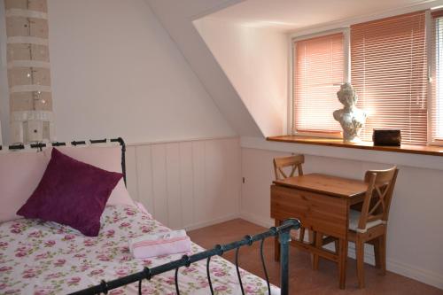 a bedroom with a bed and a desk and a window at B&B MACBED CHECKIN-TIME 1700-1800 or request before you book in Alkmaar