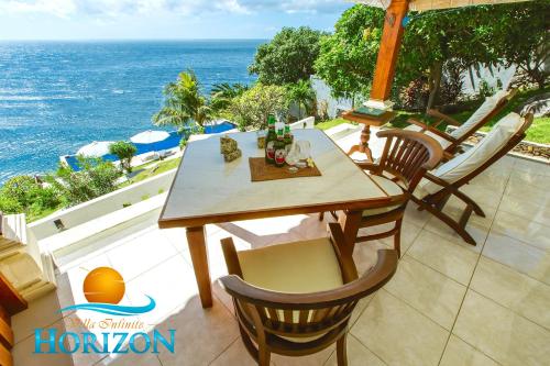 a table and chairs on a patio overlooking the ocean at Villa Infinite Horizon in Amed