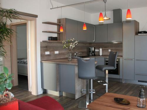 eine Küche mit einer Theke und Stühlen in einem Zimmer in der Unterkunft Villa Glückspilz in Kühlungsborn