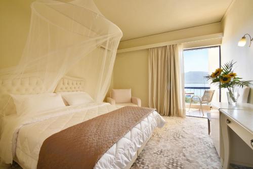 a bedroom with a bed with a mosquito net at Ionion Star Hotel in Lefkada Town