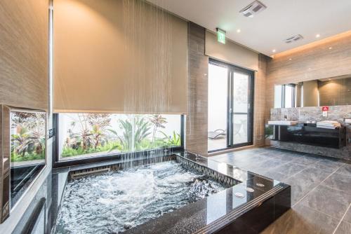 a large bathroom with a fish pond in the middle at Voga Motel in Taichung