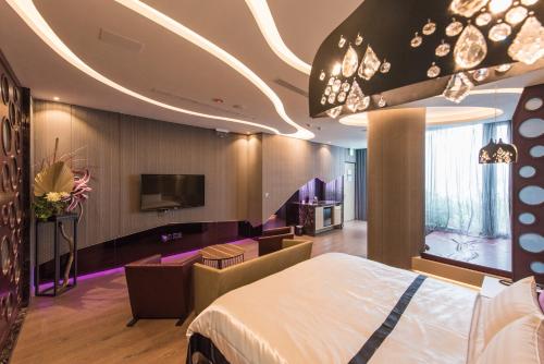 a hotel room with a bed and a tv at Voga Motel in Taichung