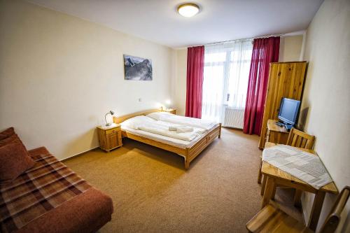 a bedroom with a bed and a tv in it at Privat Galfy in Smokovce