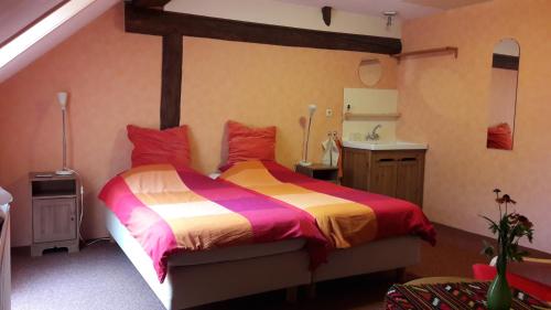 a bedroom with a large bed and a sink at Bed & Breakfast Onder Dak in Scharmer