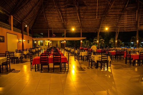 an empty restaurant with tables and chairs at night at South Beach Resort in Dar es Salaam