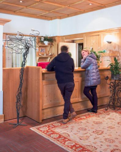 two people standing at a counter in a room at Antico Albergo Stella d'Italia in Folgaria