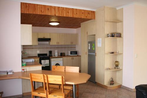 a kitchen with a wooden table and chairs in it at Maggie´s Accommodation in Swakopmund