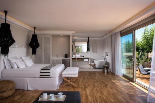 a bedroom with a white bed and a bathroom at Sunvillage Malia Boutique Hotel and Suites in Malia