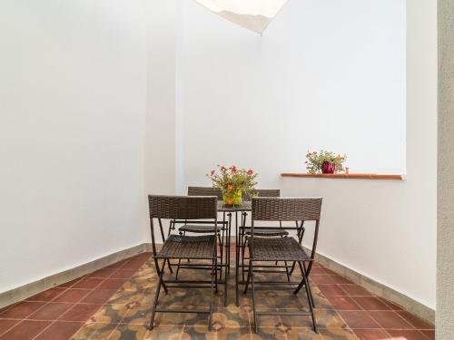 a dining room table with chairs and flowers on it at Charming Rooms Opuntia in Carloforte