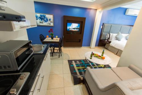اجنحة بيسان الجبيل في الجبيل: مطبخ وغرفة معيشة مع أريكة وطاولة