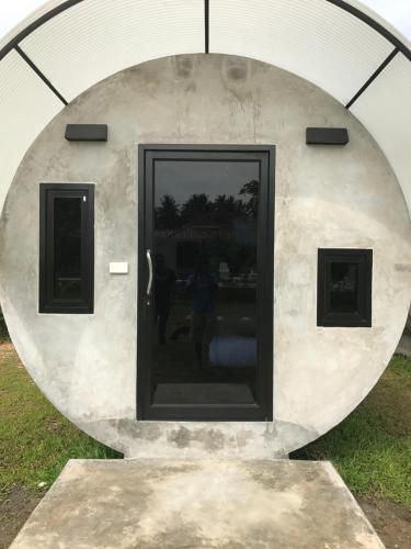 a round building with a door in the grass at Saree Lagoon Villa Koh Samui in Lipa Noi