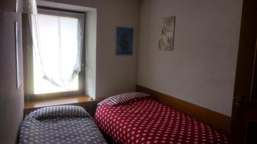 una camera con letto rosso e finestra di Luigi Apartment a Varena