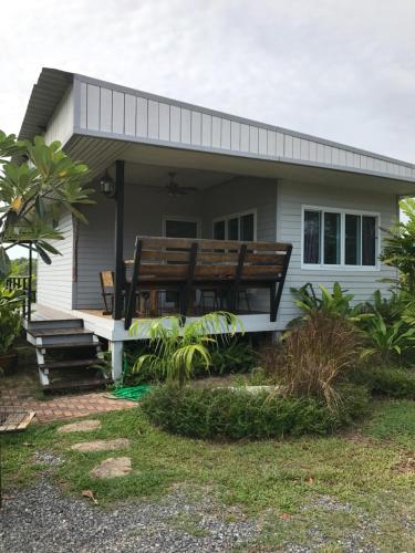a small white house with a large wooden bench at Saree Lagoon Villa Koh Samui in Lipa Noi