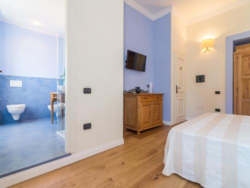 a bedroom with a bed and a bathroom with a toilet at Charming Rooms Opuntia in Carloforte