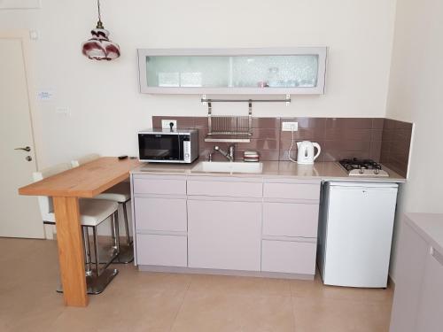 a small kitchen with a sink and a microwave at HaYarkon Street Apartment in Tel Aviv
