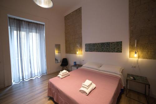 a bedroom with a large bed with two towels on it at Borgo Vergini Garden B&B in Naples