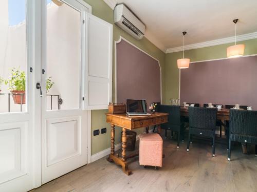 卡洛福泰的住宿－Charming Rooms Opuntia，用餐室配有带笔记本电脑的桌子