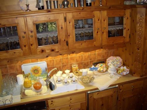 a kitchen with wooden cabinets and a counter full of food at Gästehaus Burgi in Fügen