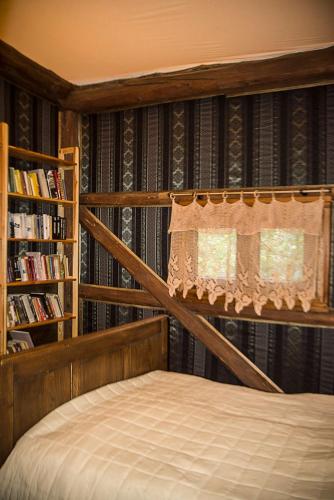 a bedroom with a bed and a book shelf at Grenlanda in Ulanów