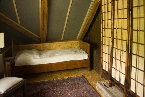 a small room with a bed in a room with windows at Grenlanda in Ulanów