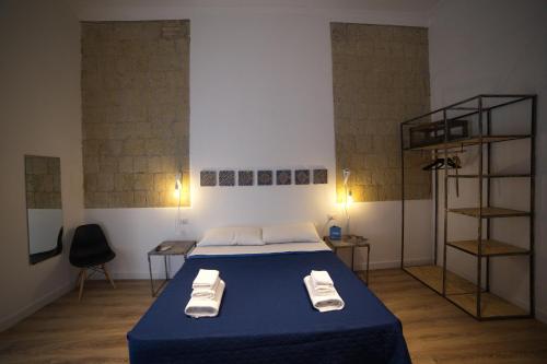 a bedroom with a blue bed with two towels on it at Borgo Vergini Garden B&B in Naples