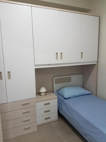 Schlafzimmer mit weißen Schränken und einem Bett in der Unterkunft The Sweet Home of Milazzo in Milazzo