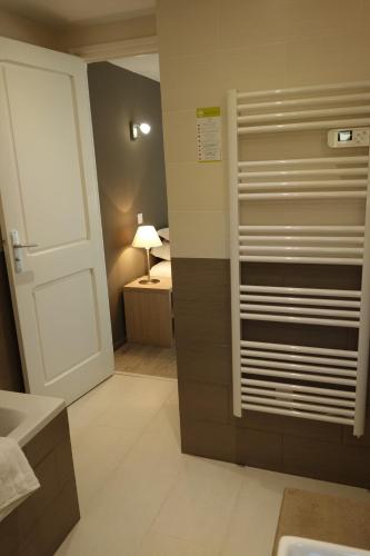 a bathroom with a white door and a bedroom at Hotel le Préjoly in Saint-Vallier-de-Thiey