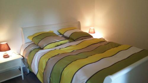 1 cama en un dormitorio con 2 lámparas en una mesa en Les grands pins en Fiquefleur-Équainville