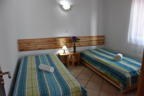1 dormitorio con 2 camas y mesa con lámpara en Adega Mourato, en Bandeiras