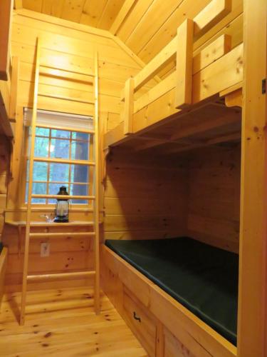 a room with two bunk beds in a wooden cabin at Okie Dokie Cabins in Tamworth