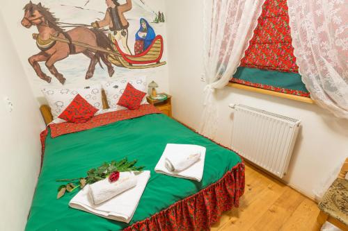 a bedroom with a green bed with a horse picture on the wall at Willa u Steni in Gliczarów