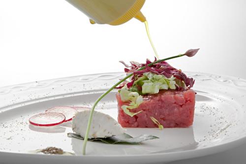 a piece of food on a white plate on a table at Osteria Senza Fretta Rooms for Rent in Cuneo