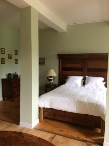 a bedroom with a large bed with a wooden headboard at Chateau du Val Larbont in La Bastide-de-Sérou