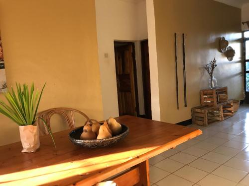 a bowl of fruit sitting on a wooden table at More Than A Drop in Moshi