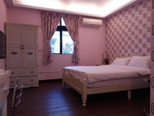 um quarto com uma cama e uma janela em Tai Yu Ju Bao Fang B&B em Yung-an-ts'un