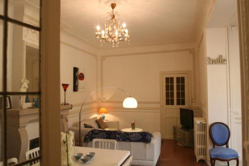 een slaapkamer met een bed en een kroonluchter bij Appart charme Arenes Nimes in Nîmes