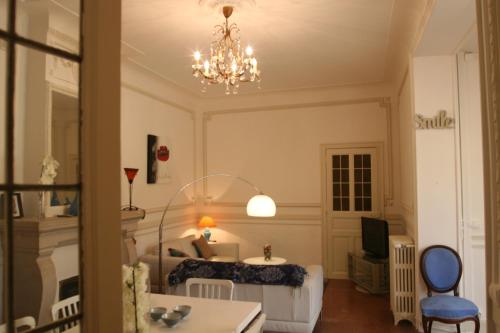 une chambre avec un lit et un lustre dans l'établissement Appart charme Arenes Nimes, à Nîmes