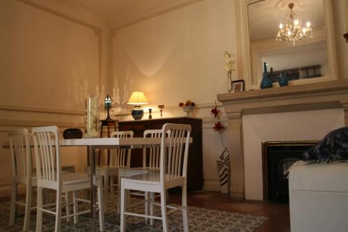 une salle à manger avec une table et des chaises et une cheminée dans l'établissement Appart charme Arenes Nimes, à Nîmes