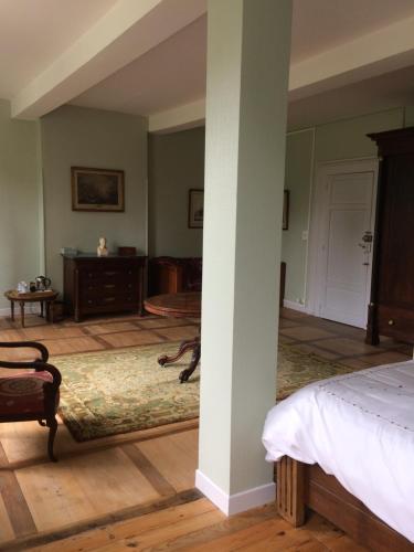 a bedroom with a bed and a table in a room at Chateau du Val Larbont in La Bastide-de-Sérou