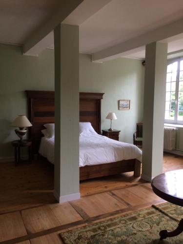 1 dormitorio con 1 cama, 2 mesas y una ventana en Chateau du Val Larbont, en La Bastide-de-Sérou