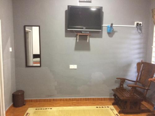 a living room with a flat screen tv on a wall at Roomstay Zulmi in Arau